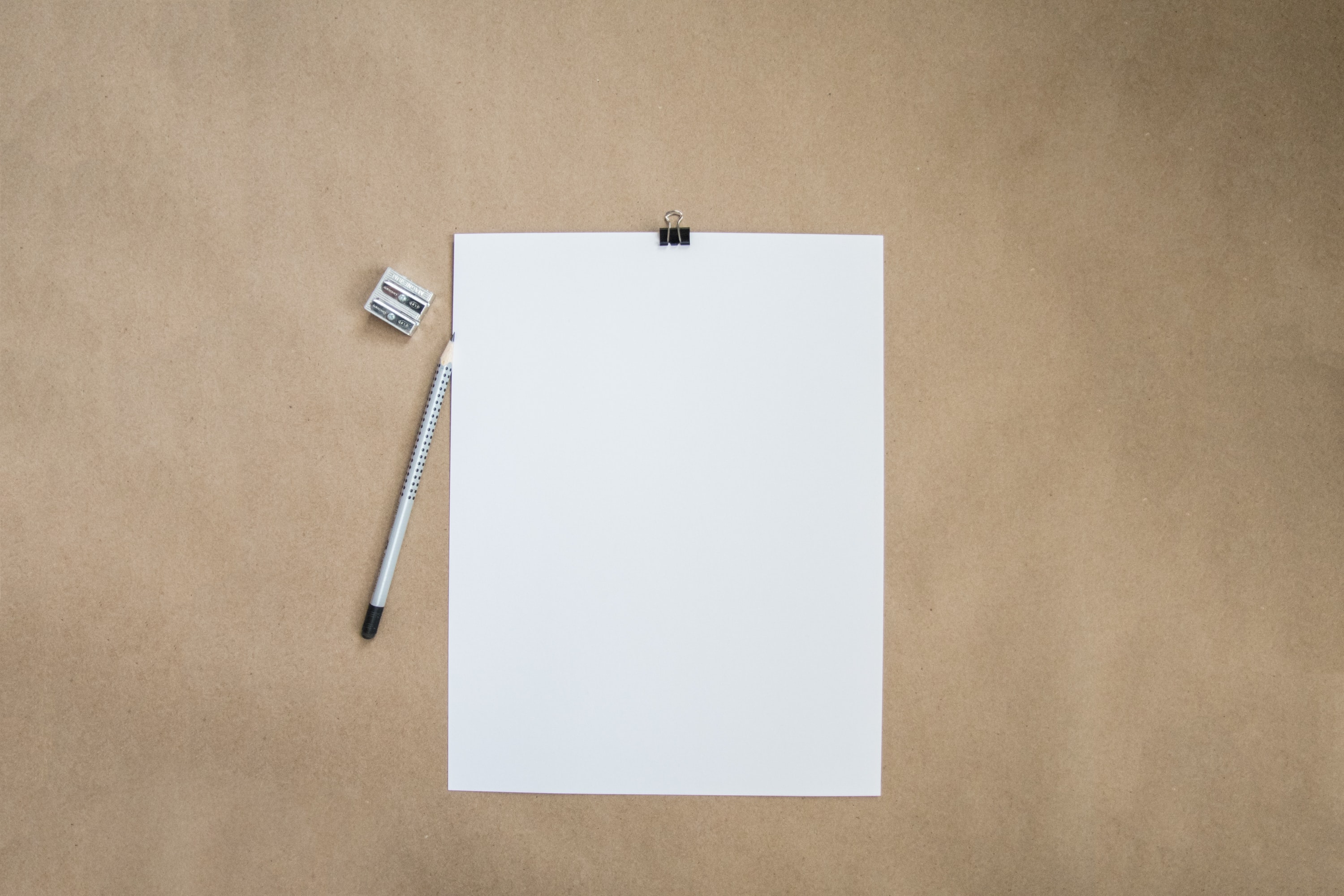 Picture of a blank piece of paper pencil and sharpener