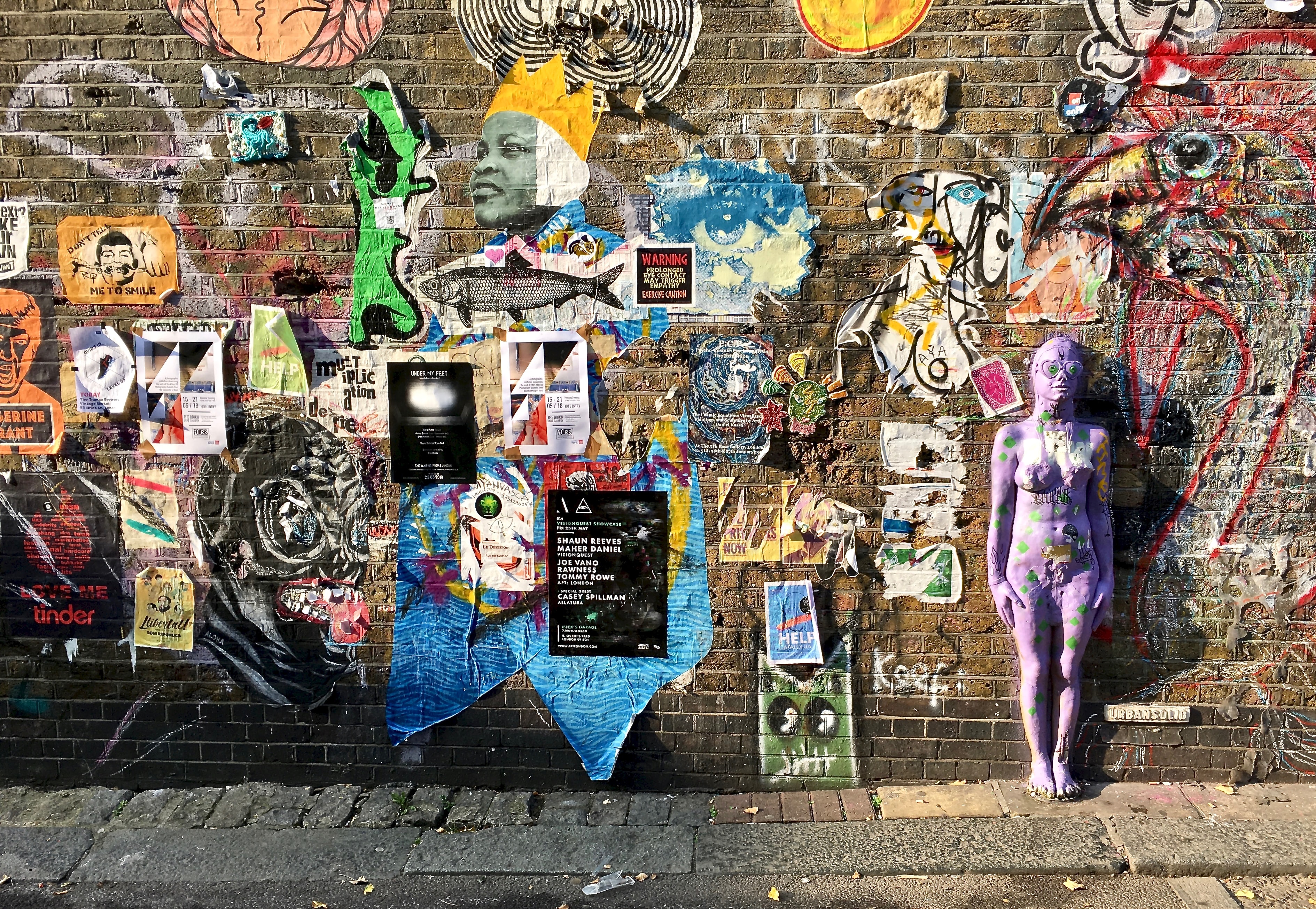 Picture of posters and stickers on a brick wall